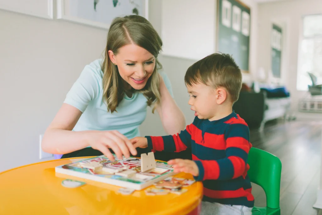 Therapist playing with a young boy at a table