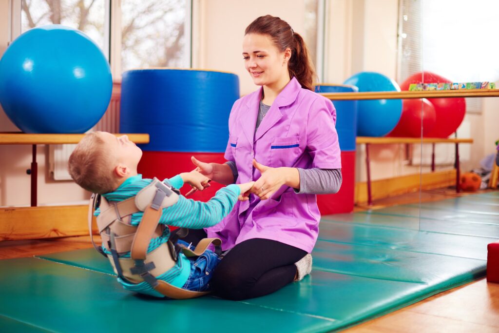 Therapist working with a young child in a therapy gym
